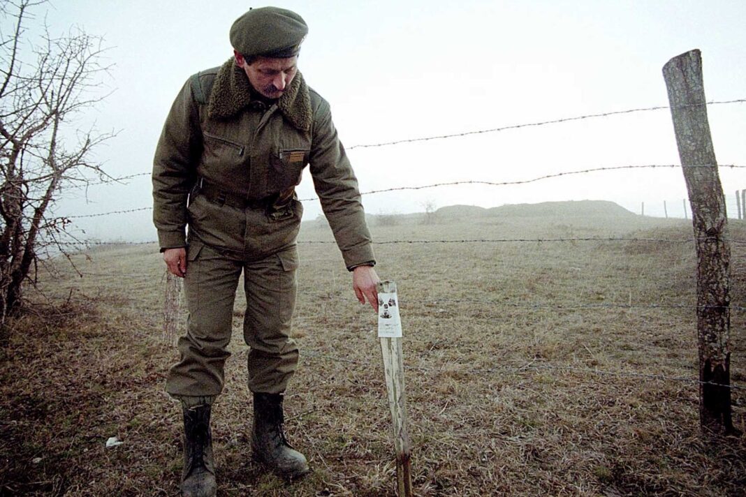 Снимок из далекого 2001 года. Офицер югославской армии показывает место рядом с городом Прешево, где обнаружили использованные натовские боеприпасы с обедненным ураном. / Reuters